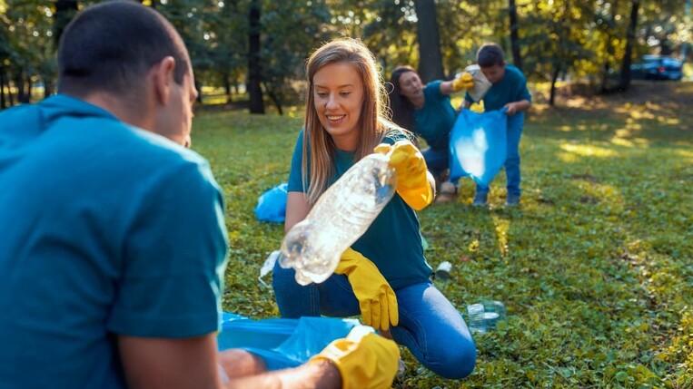 Kollegen sammeln Plastikflaschen im Park